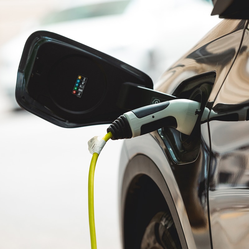 Installation de panneaux solaires : Ouvriers sur le toit. Deux ouvriers avec casques et harnais installent des panneaux solaires photovoltaïques sur un toit, au soleil couchant.